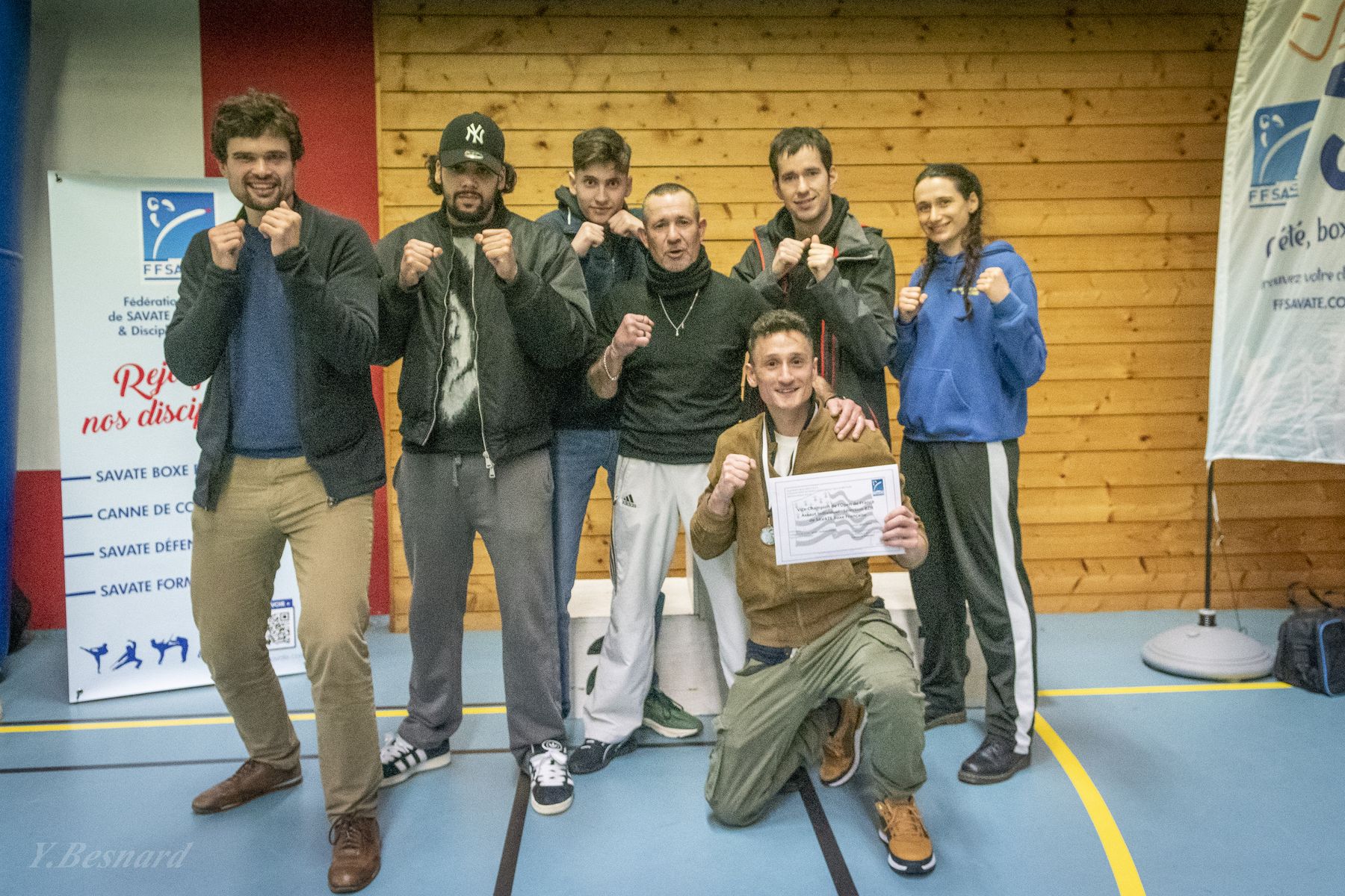 Un groupe d’éducateurs pose avec leurs diplômes devant les affiches de la Ligue