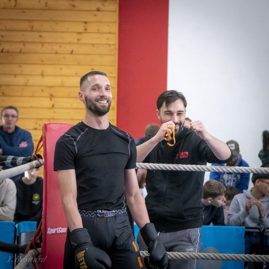 Deux entraîneurs souriants au bord du ring