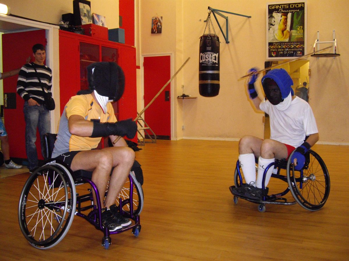 Deux pratiquants en fauteuil roulant font de la canne de combat