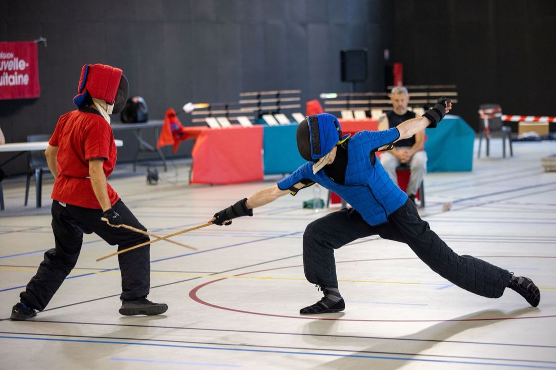 Deux tireurs de canne de combat masqués, l’un en fente