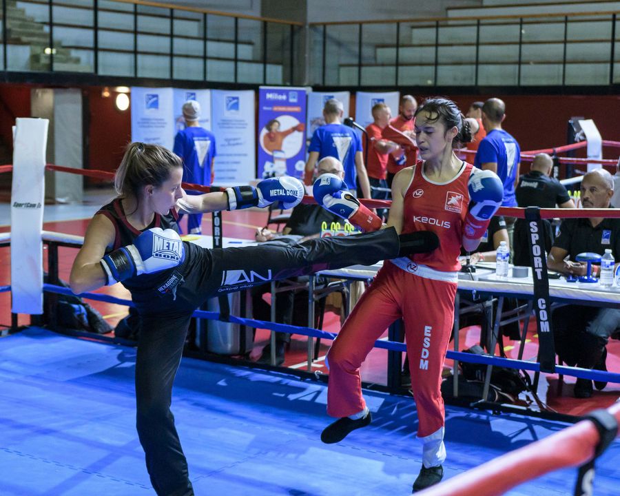 Une tireuse lance un coup de pied à son adversaire en rouge