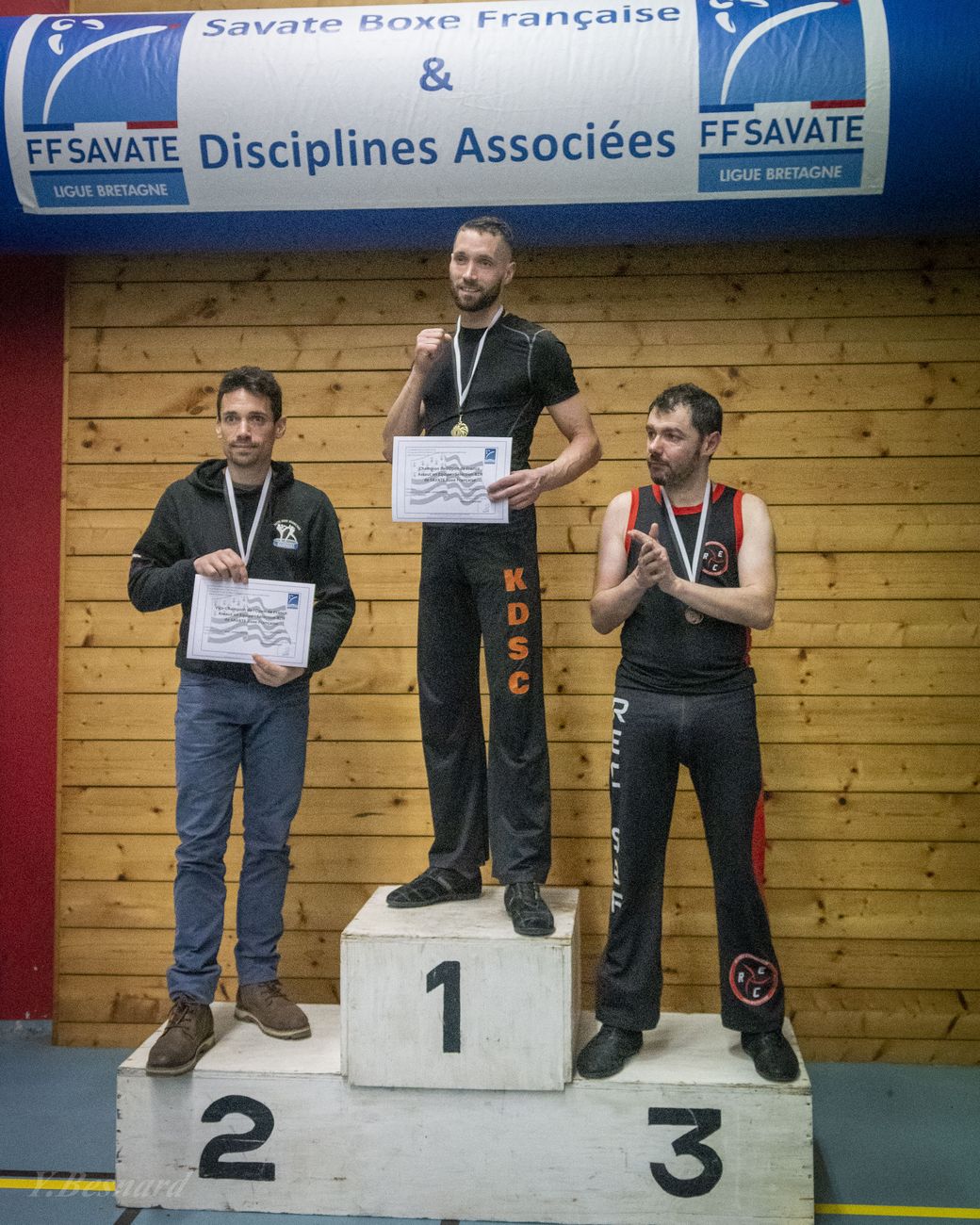 Podium masculin devant la banderole de la Ligue